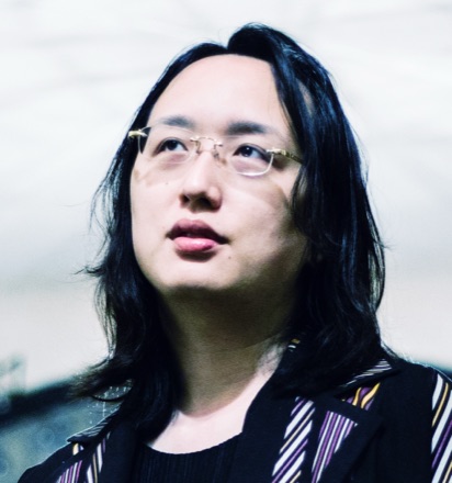 Audrey Tang photographed in close-up, wearing glasses and a patterned jacket.
