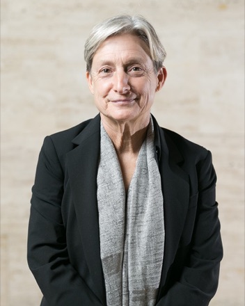 Judith Butler photographed in 2018 at the CCCB in Barcelona, in a dark jacket and grey scarf, looking towards the camera.