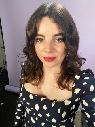 Shon Faye, with dark wavy hair and red lipstick, in a polka-dot top.
